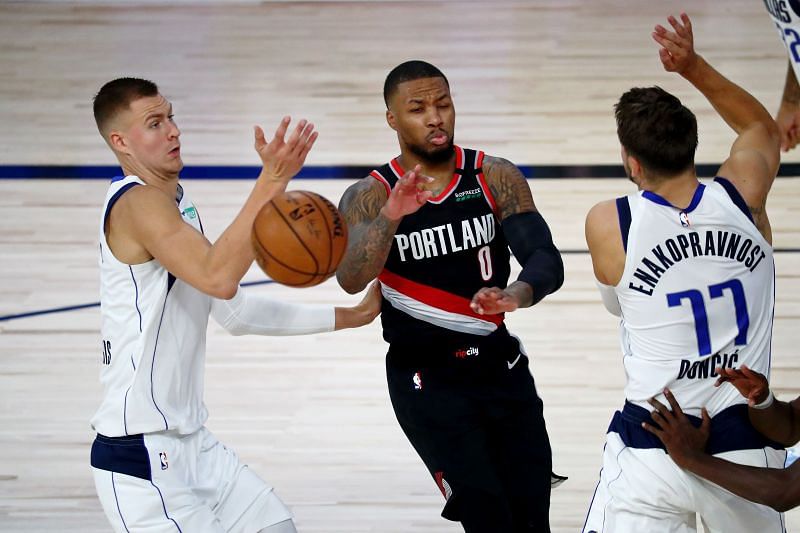 Damian Lillard (left) has the ball knocked loose on a drive against Kristaps Porzingis and Luka Doncic.&nbsp;