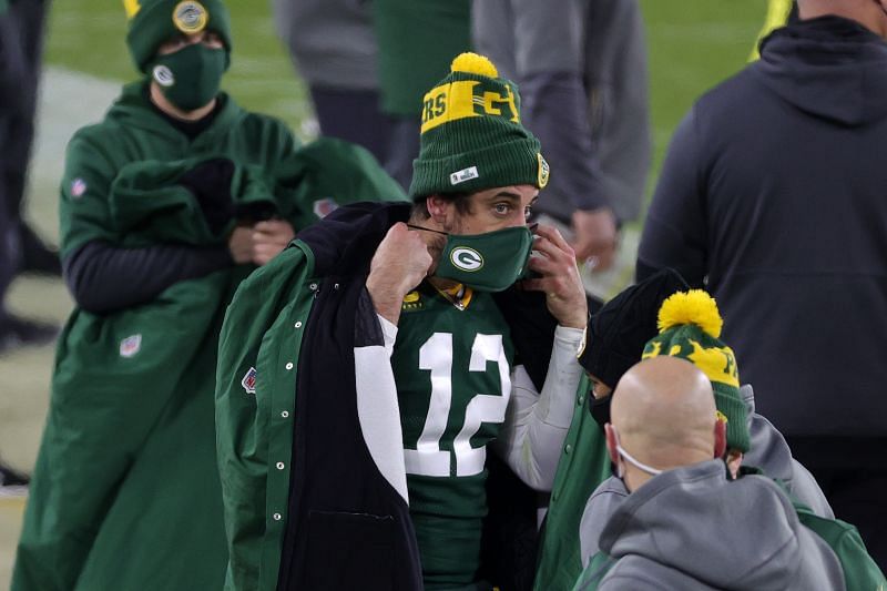 Aaron Rodgers puts on his Green Bay Packers themed face mask