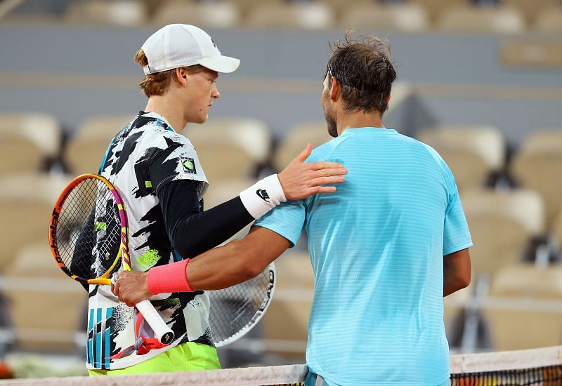 Jannik Sinner (L) &amp; Rafael Nadal embrace at the net