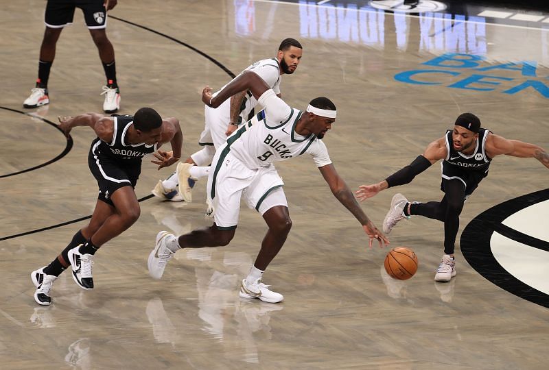 Bobby Portis #9 of the Milwaukee Bucks drives against Reggie Perry #0, and Bruce Brown #1 of the Brooklyn Nets.