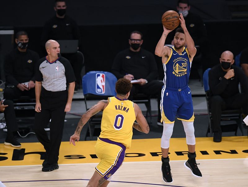 Stephen Curry of the Golden State Warriors shoots a three pointer in front of Kyle Kuzma of the LA Lakers.