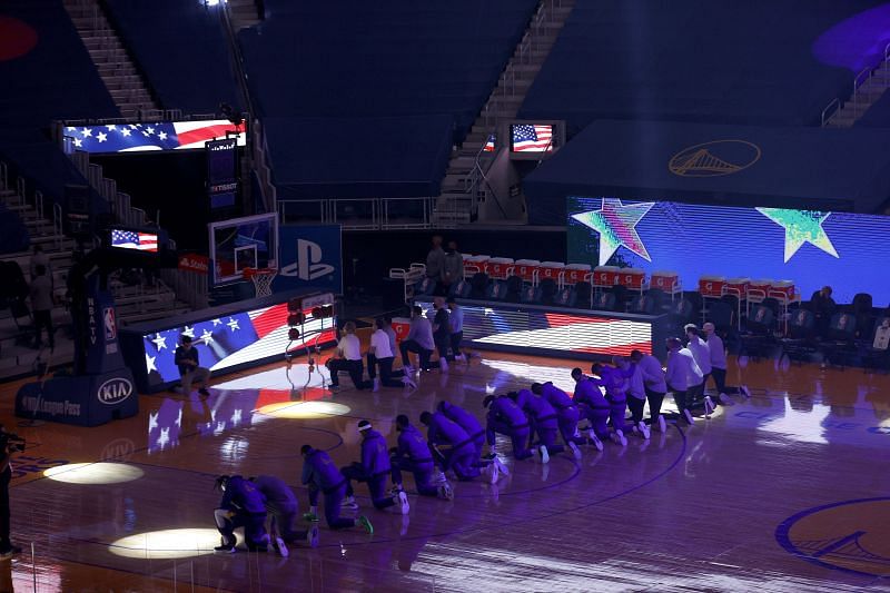 The Golden State Warriors take a knee for the national anthem.