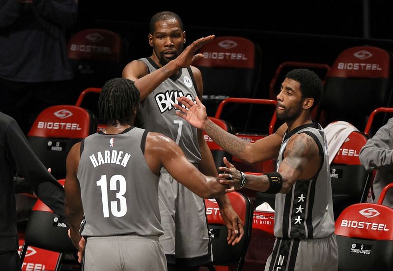 James Harden #13, Kevin Durant #7, and Kyrie Irving #11 of the Brooklyn Nets high-five after defeating Bam Adebayo and the Miami Heat