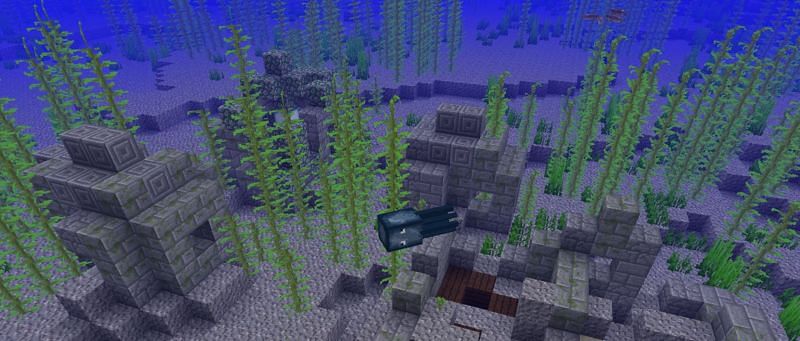 Underwater ruins with a squid mob swimming by in Minecraft. (Image via Minecraft.net)