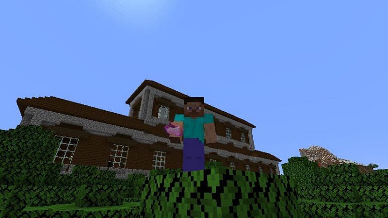 Steve holding an enchanted golden apple near a woodland mansion in Minecraft. (Image via Minecraft)