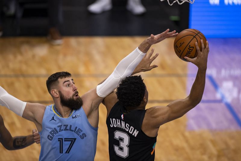 Jonas Valanciunas #17 of the Memphis Grizzlies defends against a shot by Keldon Johnson #3 of the San Antonio Spurs.