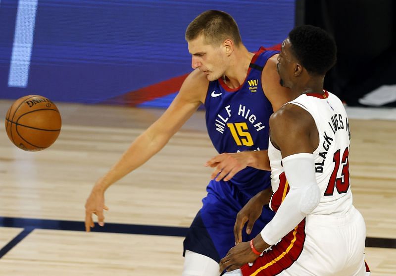 Nikola Jokic, #15 of the Denver Nuggets, loses the ball against Bam Adebayo, #13 of the Miami Heat