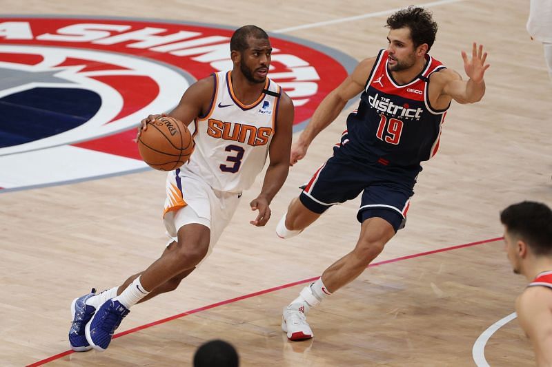 Chris Paul of the Phoenix Suns dribbles in front of Raul Neto of the Washington Wizards