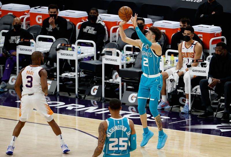LaMelo Ball #2 of the Charlotte Hornets puts up a three-point shot over Chris Paul #3 of the Phoenix Suns 