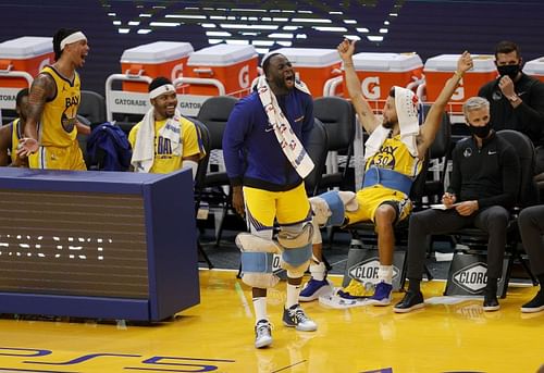 Damion Lee #1, Kent Bazemore #26, Draymond Green #23, and Stephen Curry #30 of the Golden State Warriors celebrate on the bench during the fourth quarter of their win over the Sacramento Kings