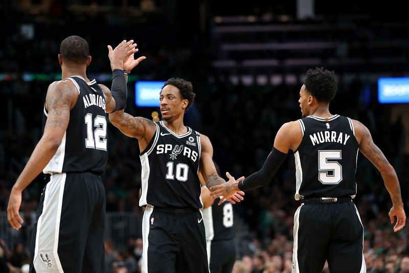 DeMar DeRozan #10 of the San Antonio Spurs celebrates with LaMarcus Aldridge #12 and Dejounte Murray #5 during the game against the Boston Celtics at TD Garden (Photo by Maddie Meyer/Getty Images)