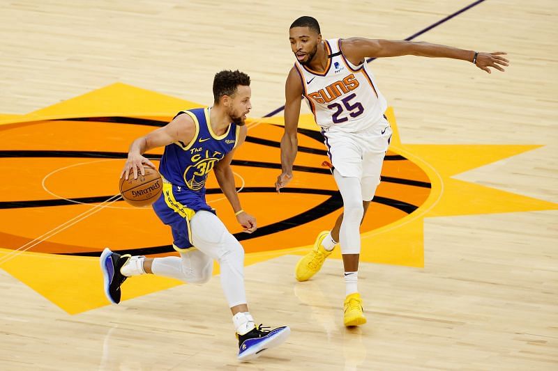 Stephen Curry of the Golden State Warriors controls the ball against Mikal Bridges of the Phoenix Suns 