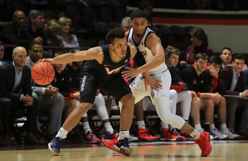 Wabissa Bede #3 of the Virginia Tech Hokies looks to dribble while being defended by Christen Cunningham #1 of the Louisville Cardinals