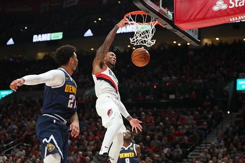 Damian Lillard #0 of the Portland Trail Blazers dunks the ball alongside Jamal Murray #27 of the Denver Nuggets in the first quarter during their season opener at Moda Center (Photo by Abbie Parr/Getty Images)