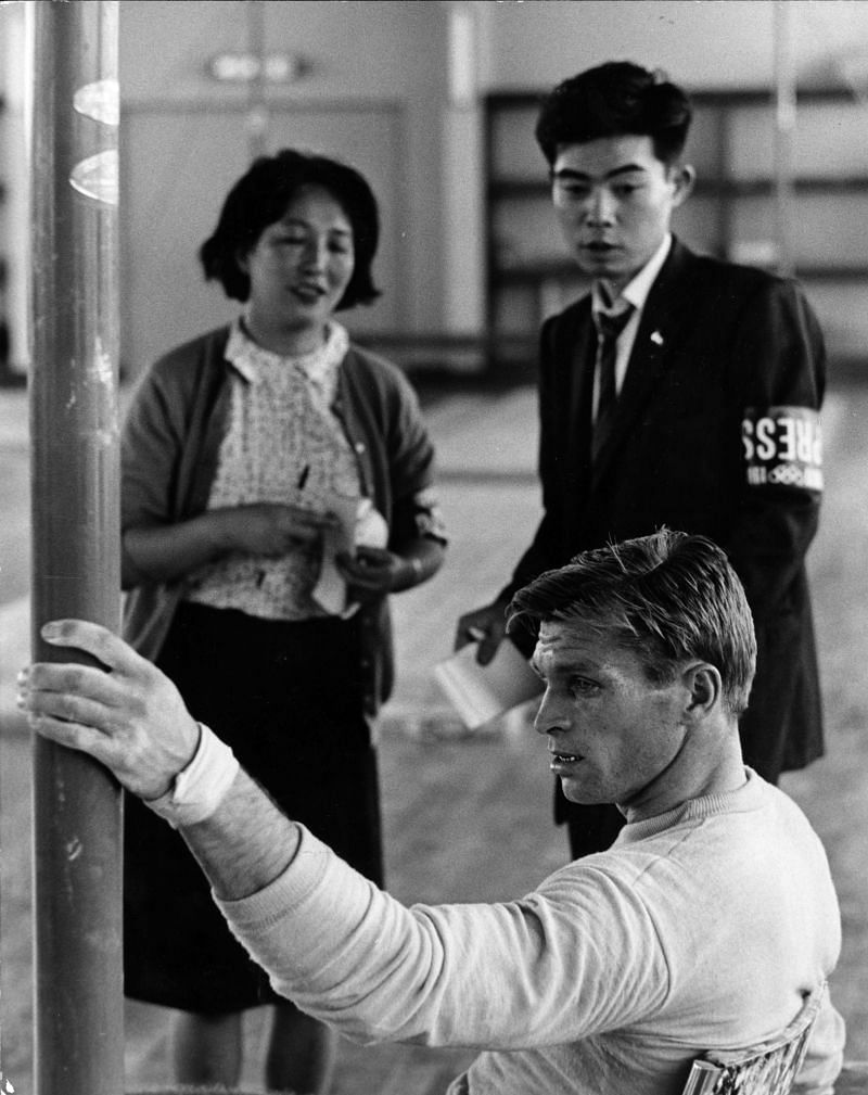 Two Japanese journalists watch champion Russian gymnast Boris Shakhlin training at Nippon University.