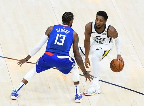 Donovan Mitchell #45 of the Utah Jazz looks to drive around Paul George #13 of the LA Clippers