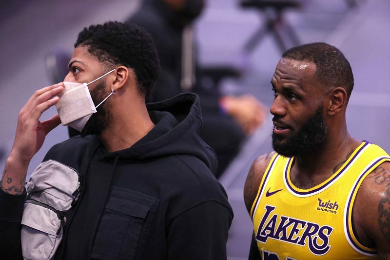 LeBron James #23 of the Los Angeles Lakers leaves the floor next to teammate Anthony Davis #3 who did not dress against the Detroit Pistons at Little Caesars Arena on January 28, 2021