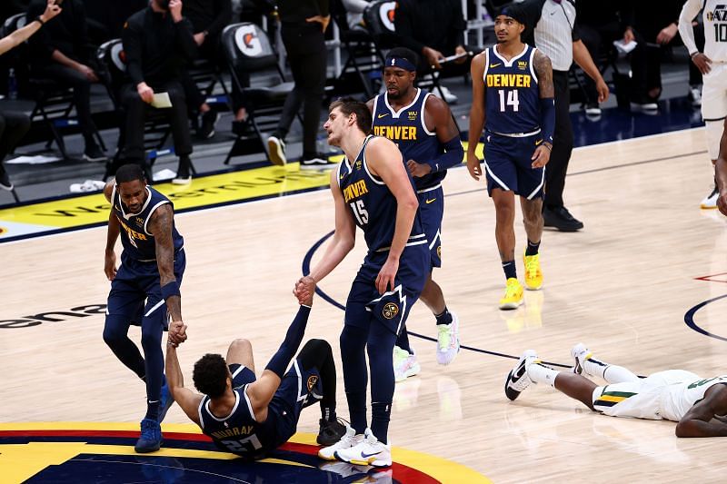 Will Barton and Nikola Jokic of the Denver Nuggets help Jamal Murray off the floor after a foul by Royce O&#039;Neale of the Utah Jazz at Ball Arena&nbsp;