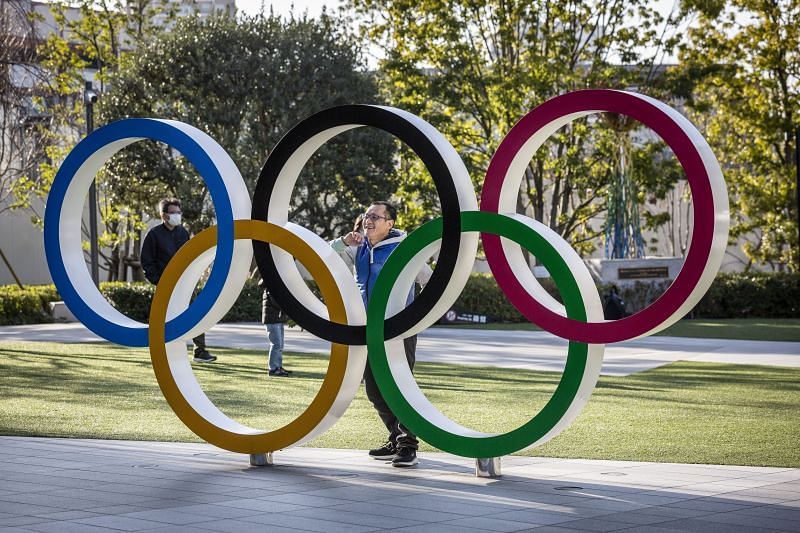 A man has his photograph taken next to the Olympic Rings in Tokyo, Japan. earlier this year
