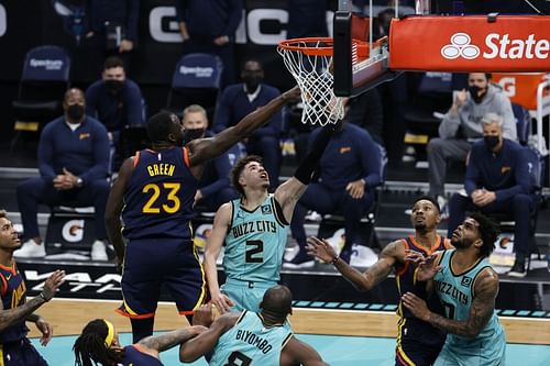 Draymond Green of the Golden State Warriors defends LaMelo Ball of the Charlotte Hornets