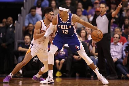 Tobias Harris of the Philadelphia 76ers goes up against Devin Booker of the Phoenix Suns