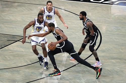 Kevin Durant #7 of the Brooklyn Nets dribbles against Andrew Wiggins #22 of the Golden State Warriors