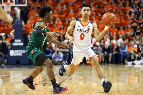 Kihei Clark #0 of the Virginia Cavaliers passes around Chris Lykes #0 of the Miami Hurricanes