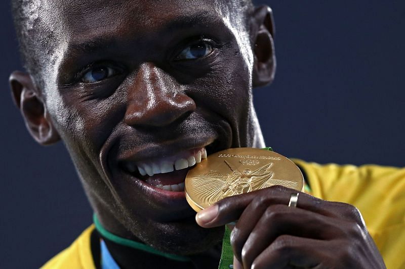 Usain Bolt biting his gold medal won at the 100m sprints at 2016 Rio Games
