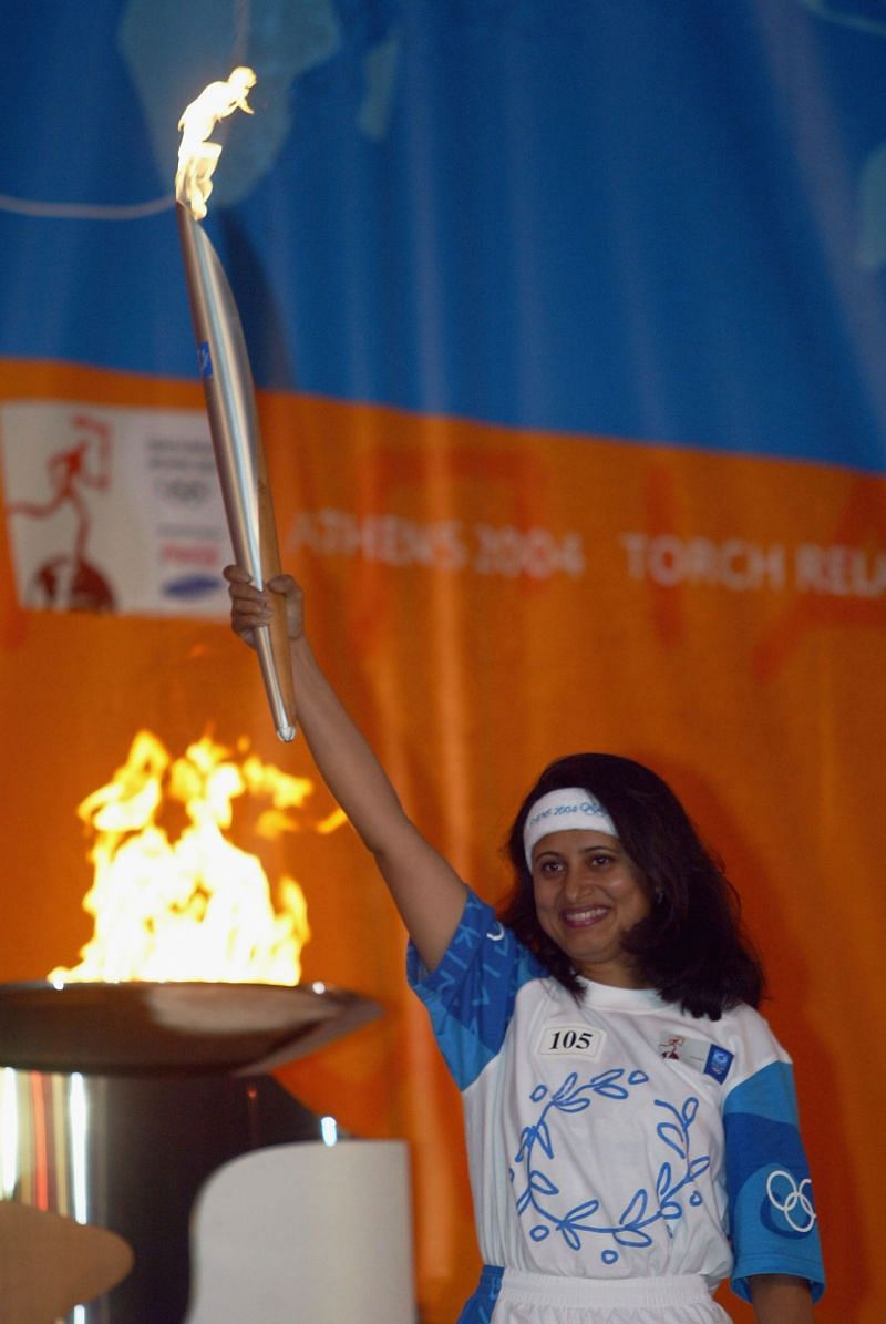 Anjali Bhagwat holding the Olympic Torch Relay at 2004 Summer Olympics