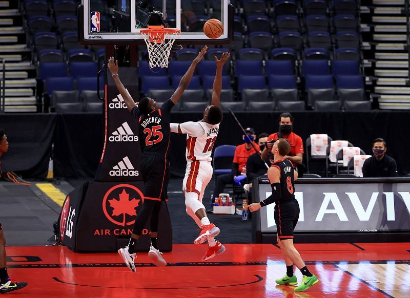 Bam Adebayo #13 of the Miami Heat drives on Chris Boucher #25 of the Toronto Raptors 
