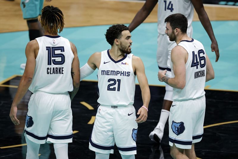 Tyus Jones #21 of the Memphis Grizzlies reacts with teammates Brandon Clarke #15 and John Konchar #46 during the fourth quarter of their game against the Charlotte Hornets at Spectrum Center (Photo by Jared C. Tilton/ Getty Images)