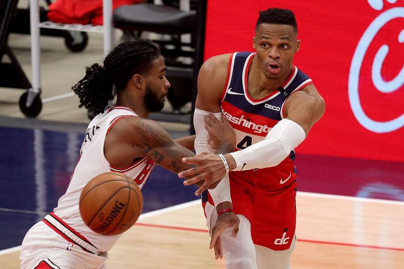 Russell Westbrook of the Washington Wizards passes around Coby White of the Chicago Bulls.
