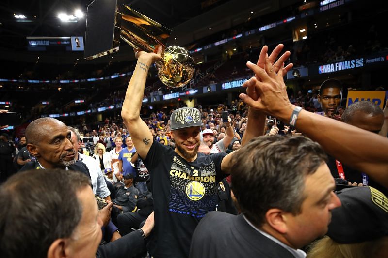 Stephen Curry #30 of the Golden State Warriors celebrates with the Larry O&#039;Brien Trophy.