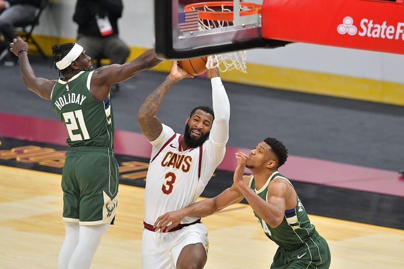 Andre Drummond of the Cleveland Cavaliers drives to the basket while under pressure from Jrue Holiday and Giannis Antetokounmpo of the Milwaukee Bucks (Photo by Jason Miller/Getty Images)