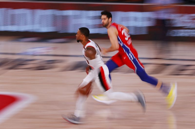 Damian Lillard #0 of the Portland Trail Blazers runs down the court against Furkan Korkmaz #30 of the Philadelphia 76ers