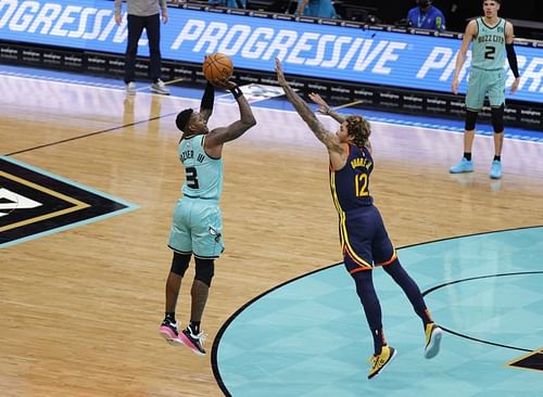 Terry Rozier #3 of the Charlotte Hornets attempts a three against Kelly Oubre Jr. #12 of the Golden State Warriors