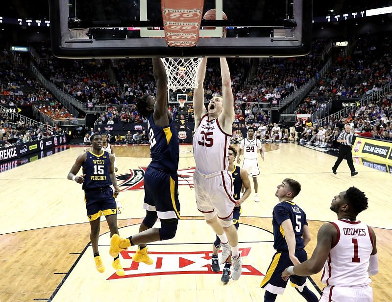 Brady Manek #35 of the Oklahoma Sooners dunks as Andrew Gordon #12 of the West Virginia Mountaineers defends