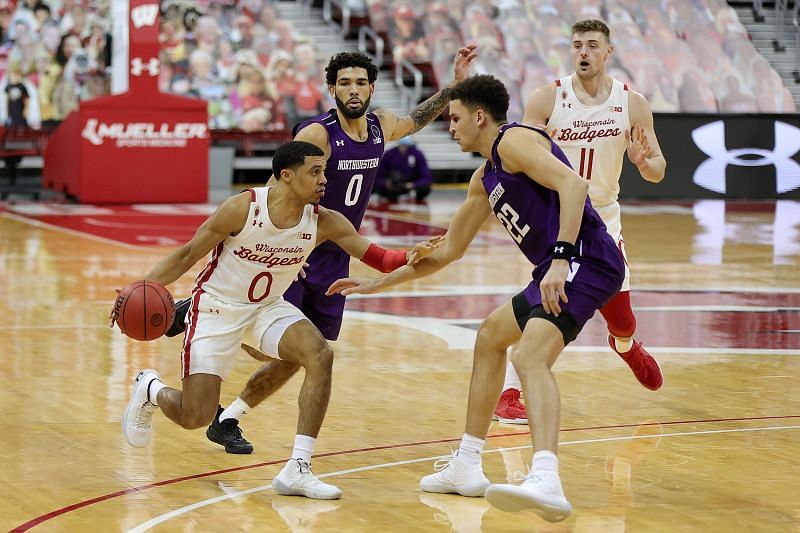 D&#039;Mitrik Trice #0 of the Wisconsin Badgers is defended by Pete Nance #22 of the Northwestern Wildcats