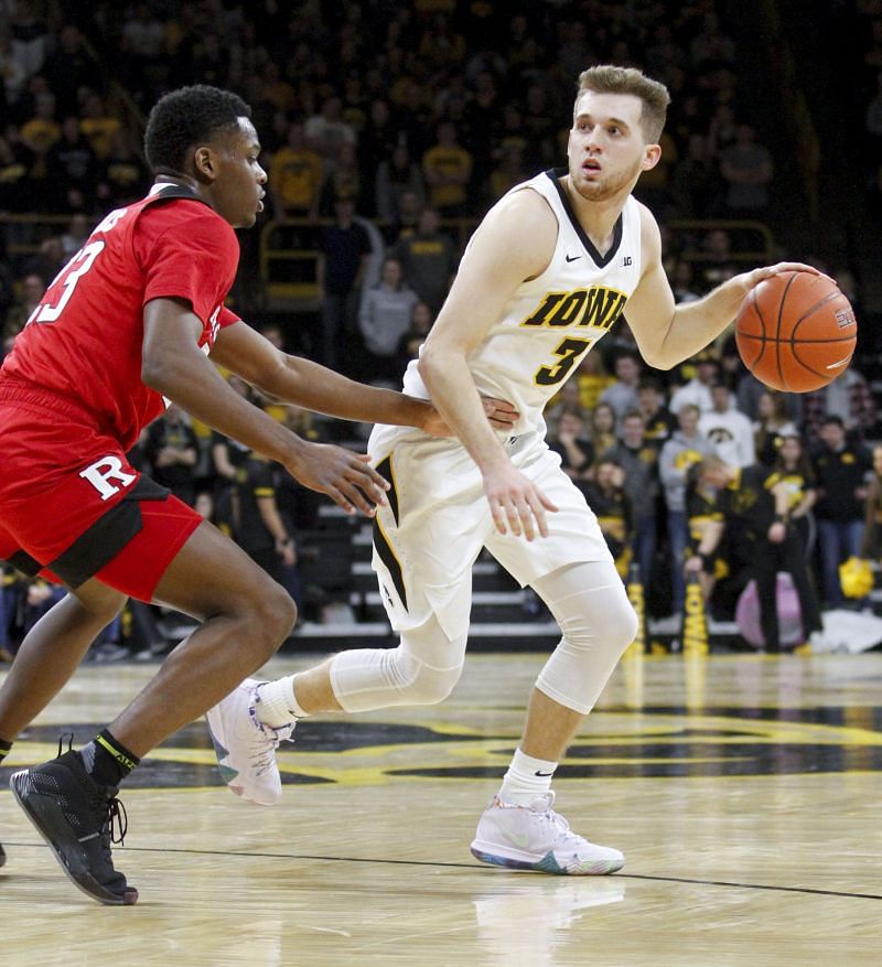Guard Jordan Bohannon #3 of the Iowa Hawkeyes moves the ball down the court in the second half against guard Montz Mathis #23 of the Rutgers Scarlet Knights