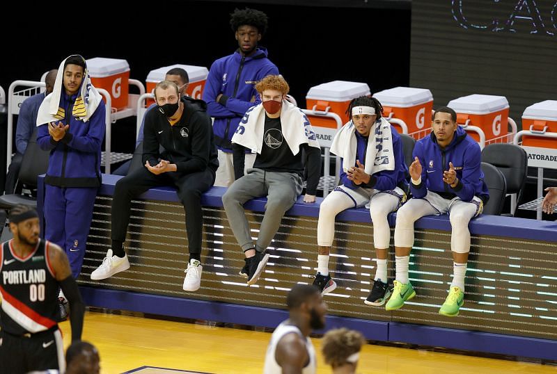 Players for the Golden State Warriors sit on a video board in front of their bench during their game against the Portland Trail Blazers at Chase Center on January 01, 2021 in San Francisco, California.