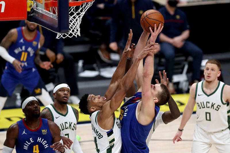 Nikola Jokic #15 of the Denver Nuggets is stopped at the rim t by Giannis Antetokounmpo.