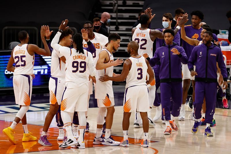 Devin Booker #1 of the Phoenix Suns celebrates with Chris Paul #3