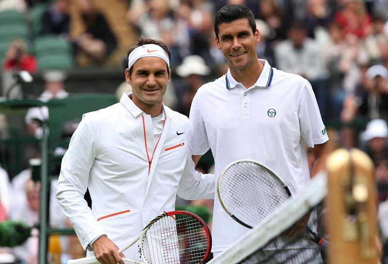 Roger Federer and Victor Hanescu pose before their first-round match at Wimbledon 2013