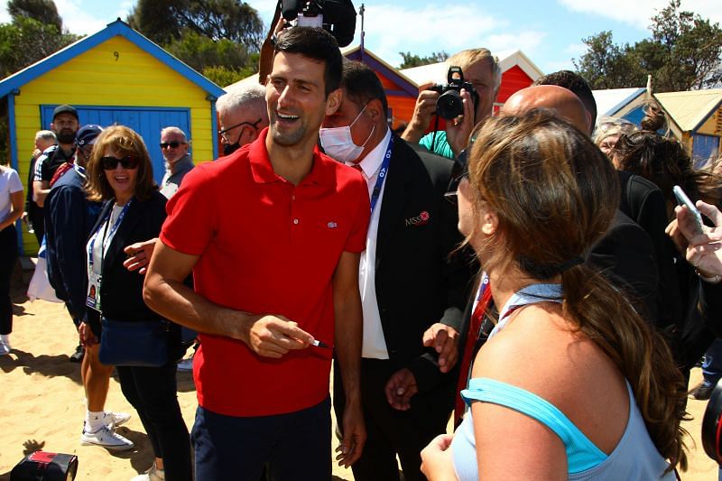 Novak Djokovic with a fan at the 2021 Australian Open Trophy Photoshoot