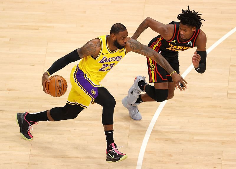 LeBron James #23 of the Los Angeles Lakers drives against Cam Reddish #22 of the Atlanta Hawks.