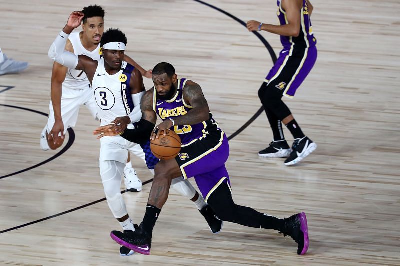 LeBron James #23 of the Los Angeles Lakers drives against Aaron Holiday #3 of the Indiana Pacers. (Photo by Kim Klement - Pool/Getty Images)