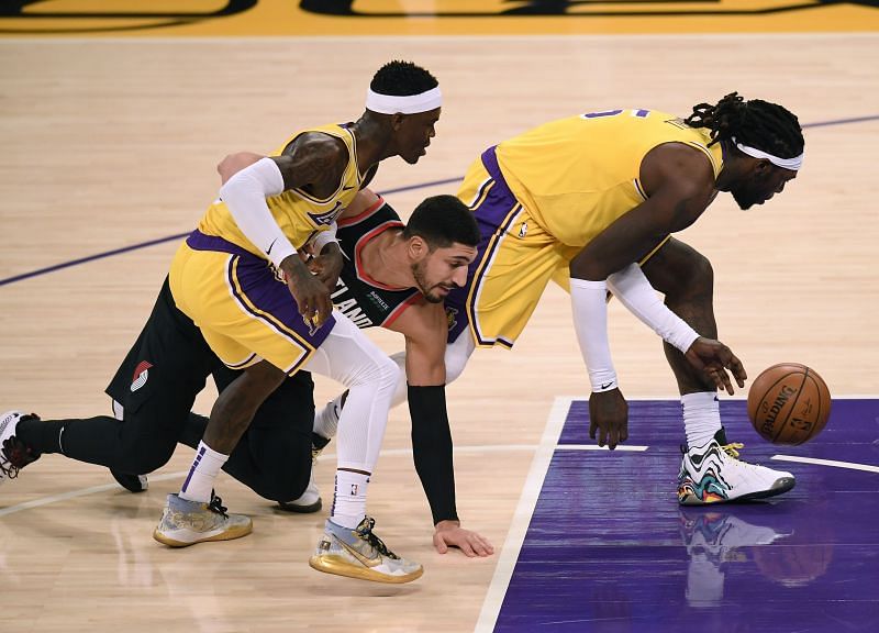 Enes Kanter #11 falls for a loose ball between Dennis Schroder #17 and Montrezl Harrell #15.