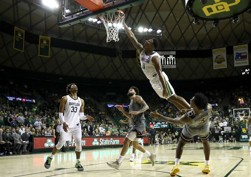 Mark Vital #11 of the Baylor Bears is fouled by Gabe Osabuohien #3 of the West Virginia Mountaineers