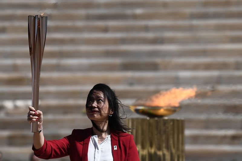 Former Japanese swimmer Imoto Naoko holds the Olympic torch during the Flame Handover Ceremony for the Tokyo 2020 Summer Olympics on March 19, 2020 in Athens, Greece.