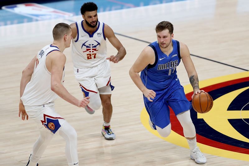Luka Doncic #77 drives against Nikola Jokic #15 and Jamal Murray #27. (Photo by Matthew Stockman/Getty Images)